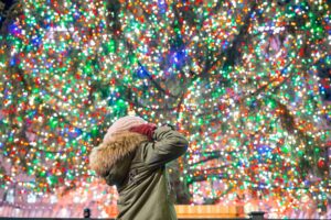 Happy girl on the background of the Rockefeller Christmas tree in New York