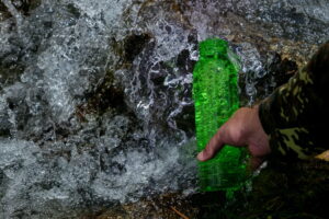Outdoor travel water bottle. Pure natural water concept. Mountain spring