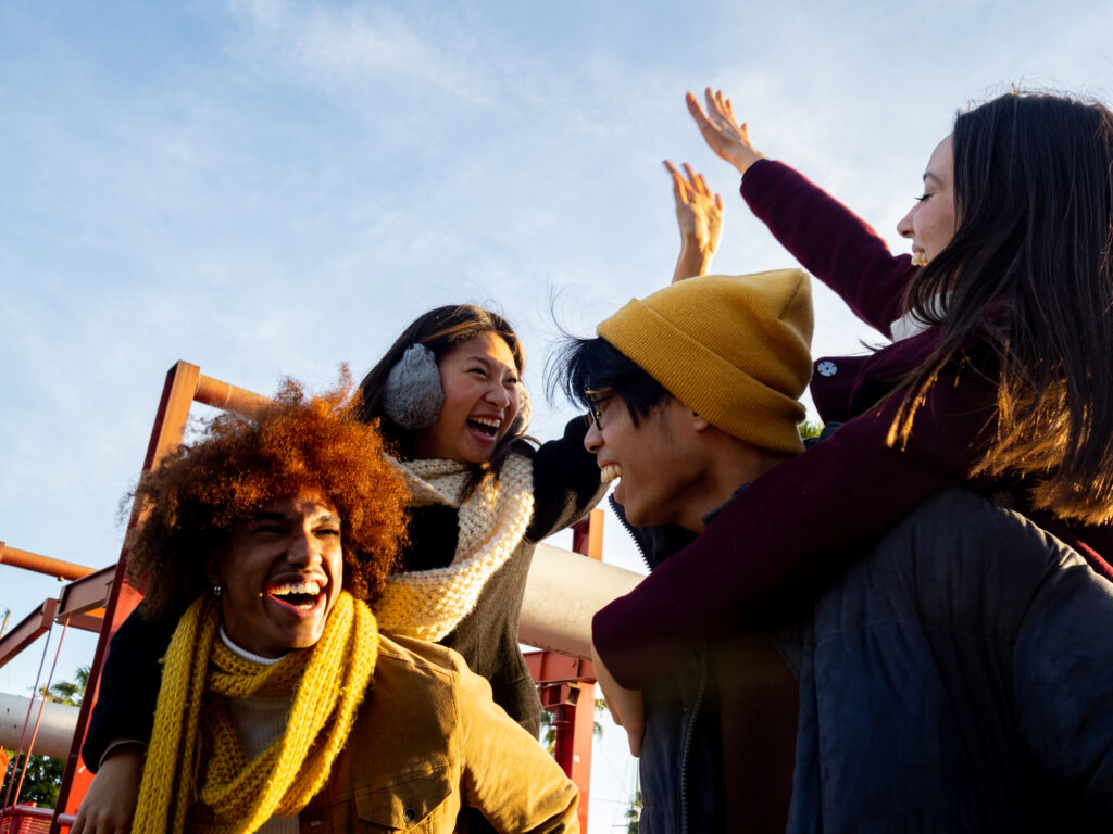 Group of multi-ethnic friends in winter clothes having a good time at the Disney park